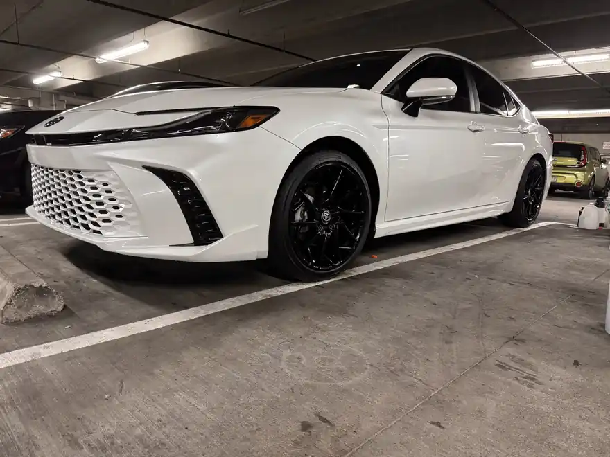 White Toyota Camry with glossy black wheels after an exterior detail